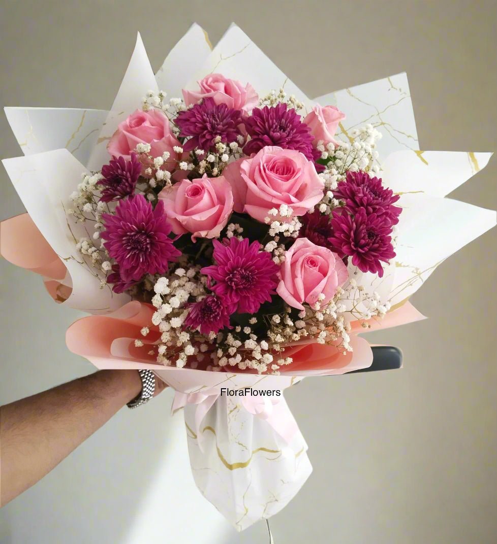 A bouquet of pink roses, purple chrysanthemums, and white baby's breath flowers with premium wrapping.