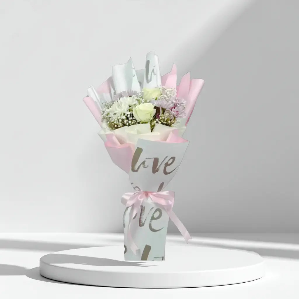 Bouquet of flowers wrapped in paper with 'love' text on a white . Send flowers to lahore. send flowers to Pakistanbackground