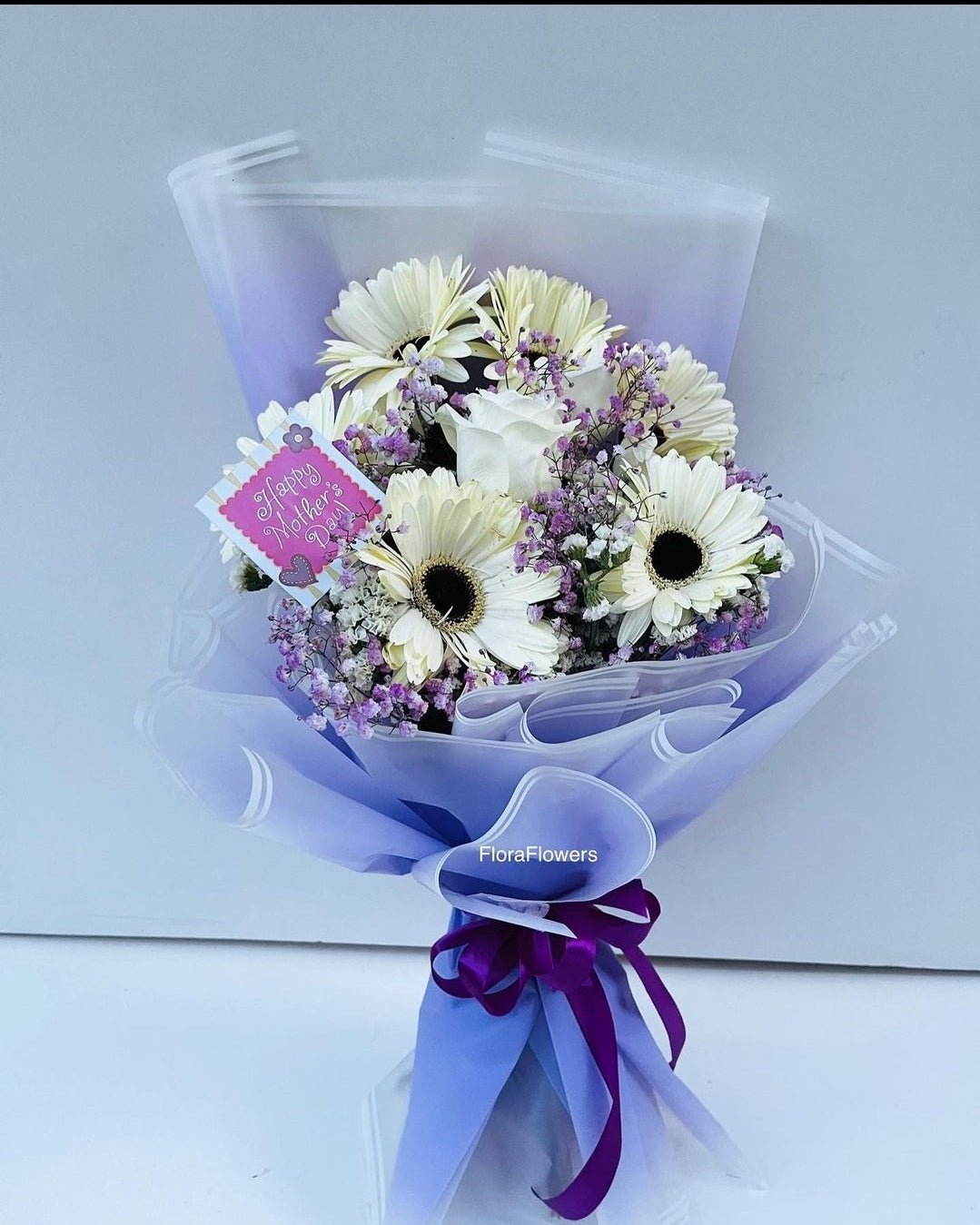 Bouquet of flowers with a visible brand label on a light gray background
