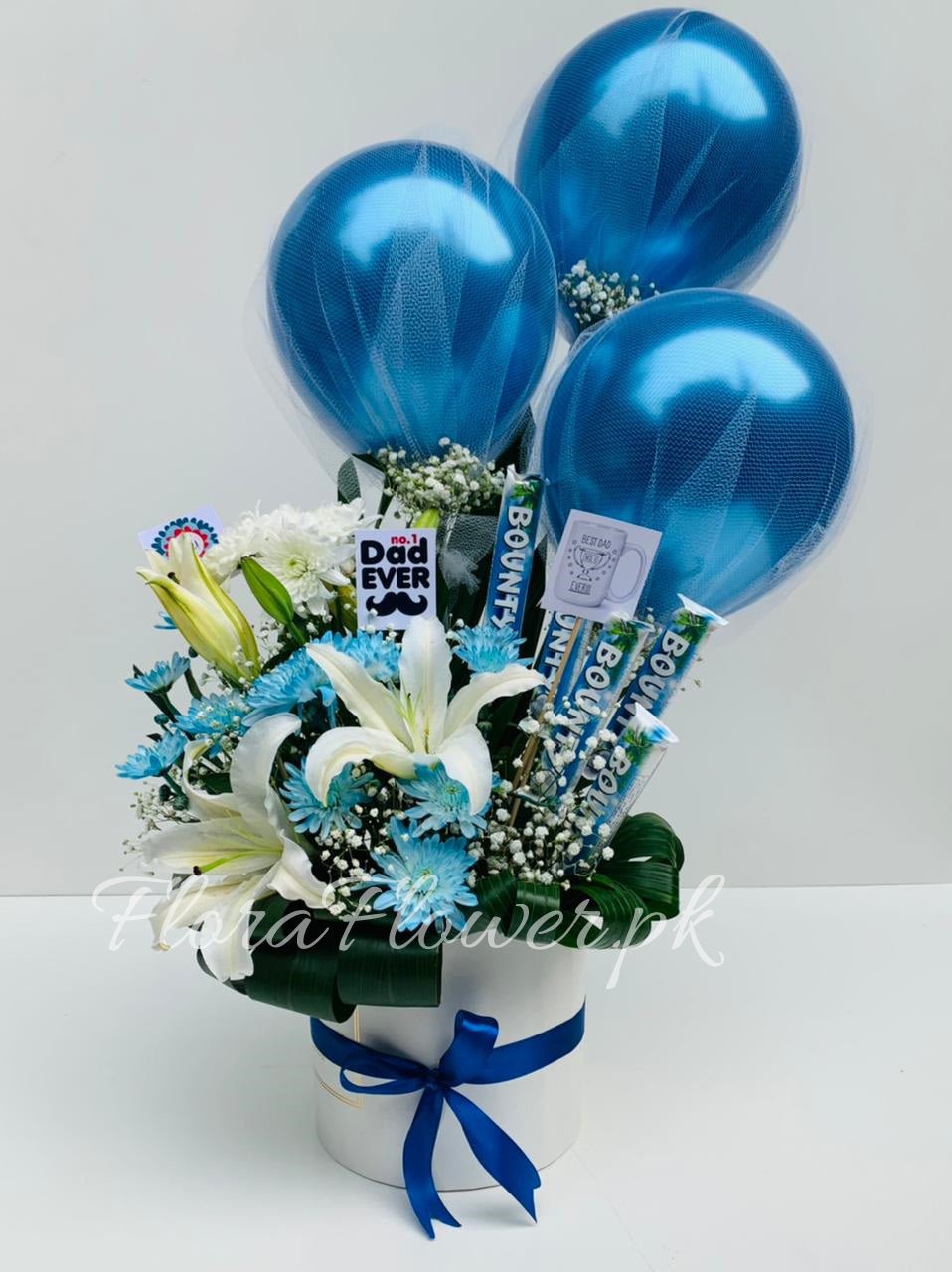 A bouquet of flowers arranged with chrysanthemums, baby's breath, balloons, and decorative elements in blue and white colors.