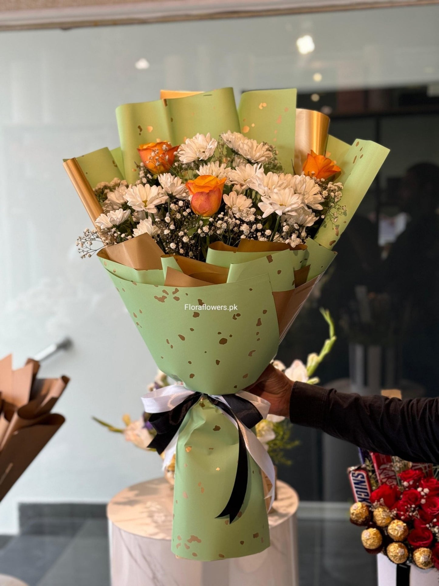 Bouquet of flowers wrapped in green paper with a blurred background