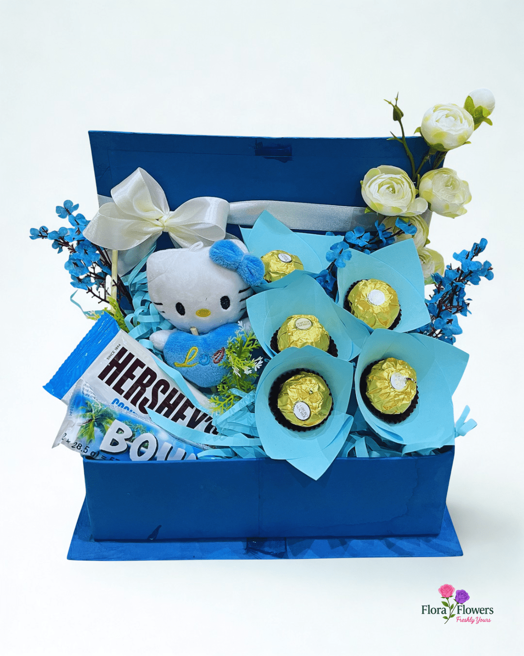 Gift basket with Hello Kitty plush toy, flowers, and chocolate bars on a white background. Send flowers to lahore. send flowers to Pakistan