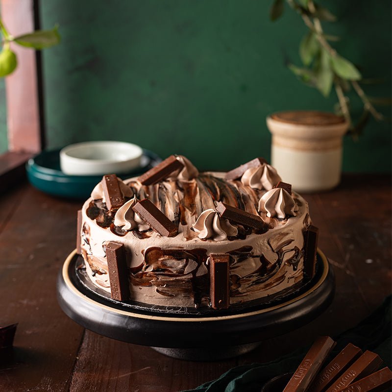 Chocolate cake with whipped cream on a wooden table with a green wall background. Send flowers to islamabad. send flowers to pakistan