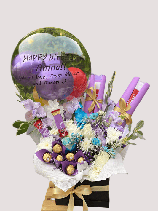 A gift arrangement featuring a assortment of fresh flowers, balloons, and chocolate candies. The arrangement includes a balloon with customizable text, six roses, three chrysanthemums, baby's breath, along with Ferrero Rocher and KitKat chocolates.