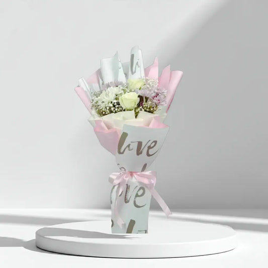 Bouquet of flowers wrapped in paper with 'love' text on a white background
