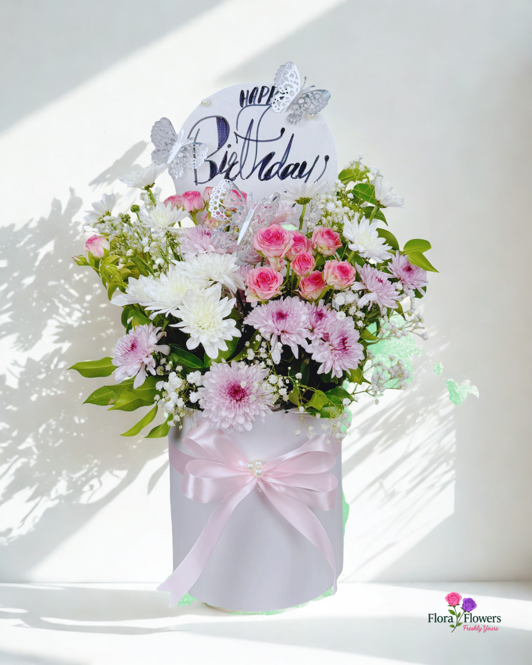 Bouquet of flowers with a 'Happy Birthday' card on a white background
