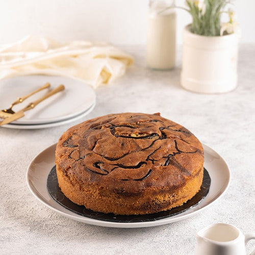 Round cake on a white plate with a light background . Send flowers to islamabad. send flowers to pakistan