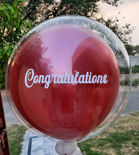 A clear balloon with the word 'Congratulations' printed in red.