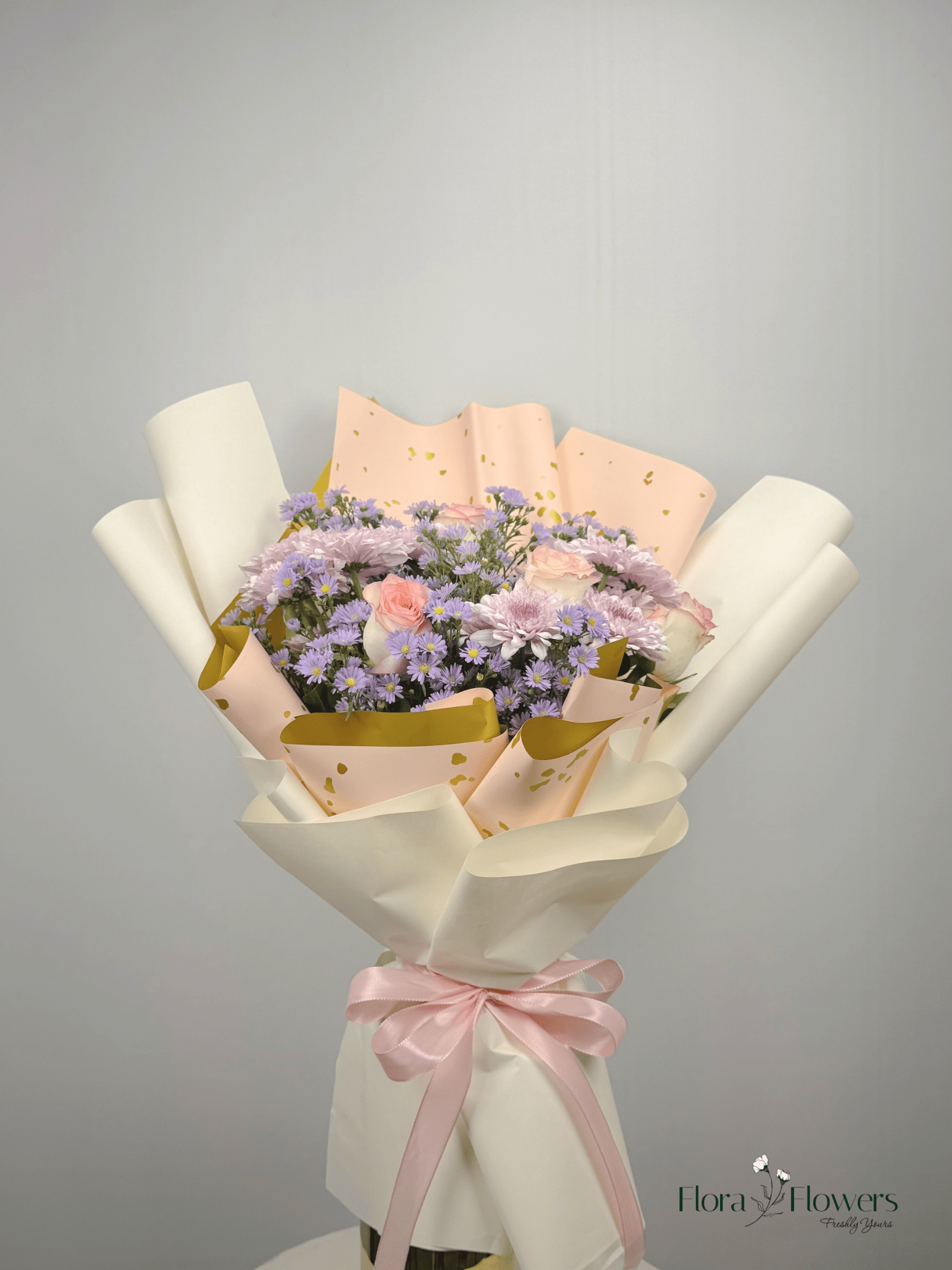 A bouquet of flowers including roses, chrysanthemums, and baby's breath, wrapped in white and pink paper with a ribbon. Send flowers to islamabad. send flowers to pakistan