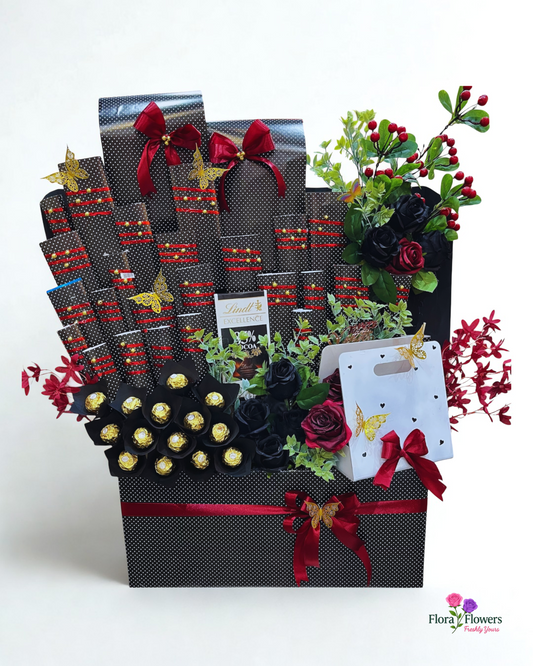 Gift basket with flowers, chocolates, and other items on a white background