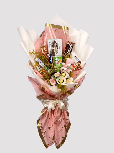A bouquet arrangement made of artificial flowers and an assortment of chocolate candies, including Twix, Ferrero Rochers, Bounty, Kinder Chocolate, Hershey's, and Pringles, wrapped in pink and white paper with ribbon.
