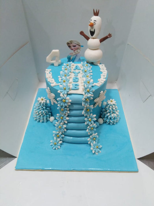 A blue birthday cake with white and silver accents, featuring character figures and a staircase made of icing.