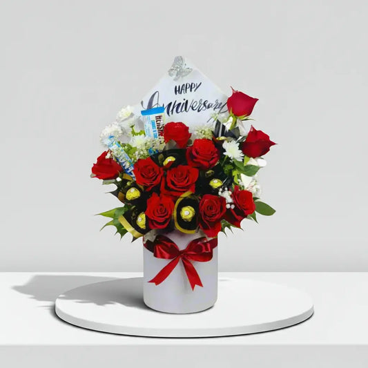 Bouquet of red roses with a 'Happy Anniversary' card on a white background