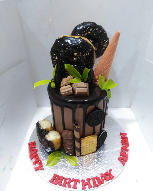 A customized cake designed to look like a donut with chocolate and strawberry toppings, presented on a plate with a 'Happy Birthday' message.