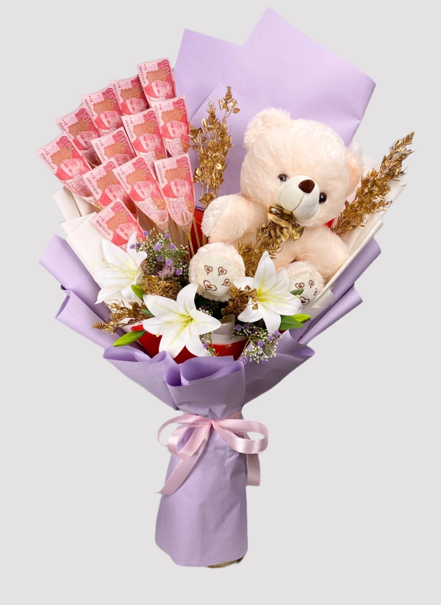 A bouquet arrangement containing artificial flowers, teddy bears, and banknotes wrapped in purple paper.