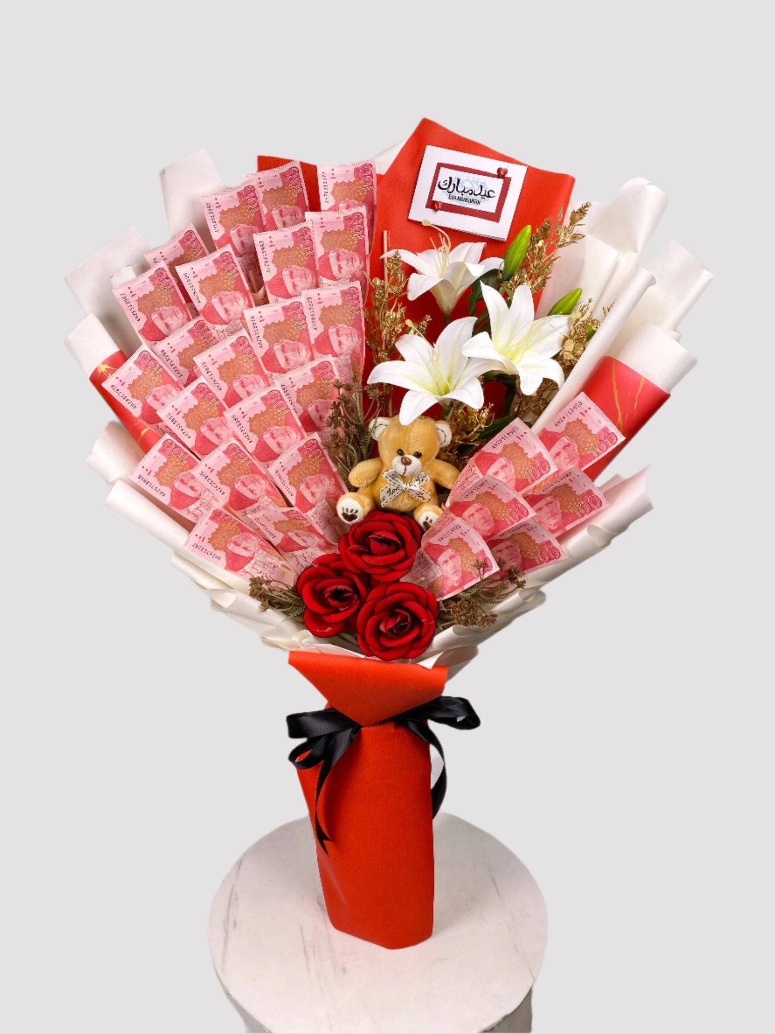 A bouquet arrangement made of banknotes, teddy bear, and artificial flowers, presented in a gift box with a ribbon.