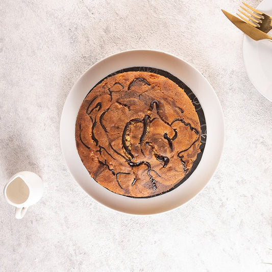 Brownie with a bear design on a white plate, placed on a light gray surface.