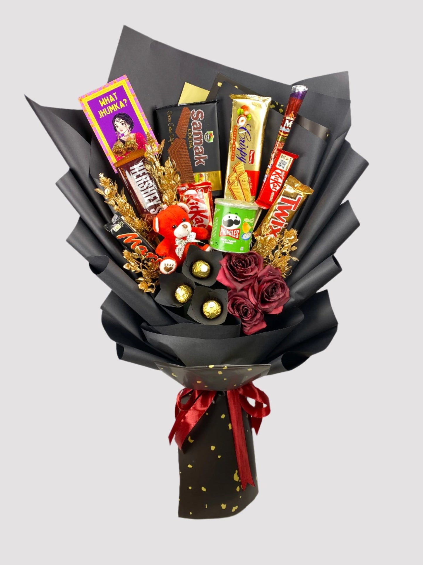 A bouquet arrangement featuring an assortment of chocolate bars and candies, with decorative elements such as Twix, Kitkat, Mars, and Hershey's, presented with artificial flowers and adorned with red ribbon.