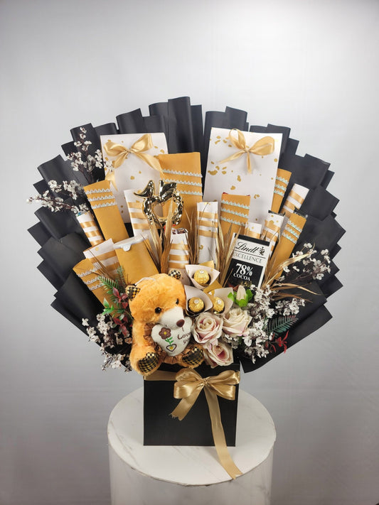 Gourmet gift basket with flowers, a teddy bear, and chocolate on a gray background