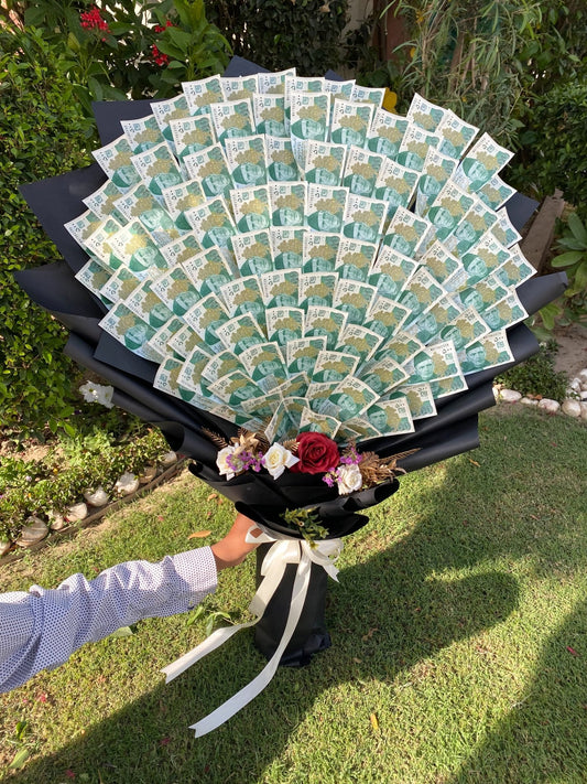 Large number of green and white cards arranged in a circular pattern on a stand outdoors.