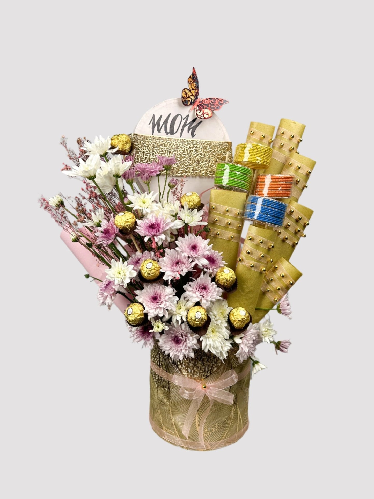 A gift arrangement featuring a variety of items including imported chrysanthemums, Ferrero Rocher, bangles, Twix, Mars, and Snickers, presented in a floral bouquet style.