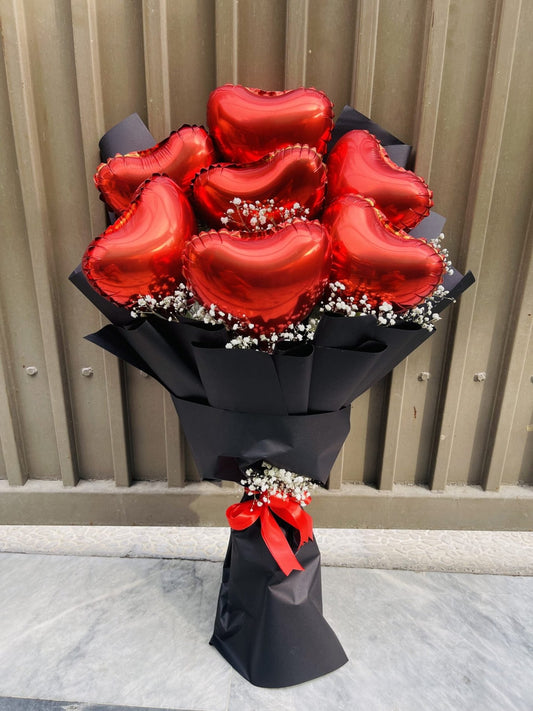 A bouquet of red heart-shaped balloons with Baby's Breath Premium wrapping sheets, presented against a metallic background.