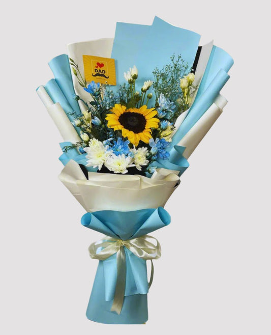 Bouquet of flowers with a sunflower, wrapped in blue paper and tied with a ribbon, on a light blue background.